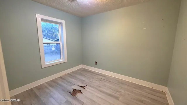 an empty room with a workspace and wooden floor