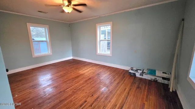 wooden floor in an empty room with a window