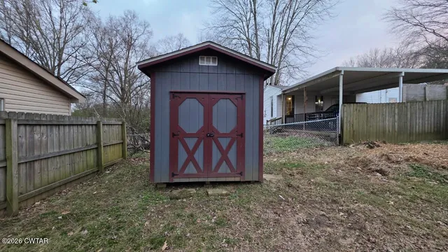 a view of backyard of house with wooden fence