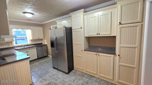a kitchen with granite countertop a refrigerator and a sink