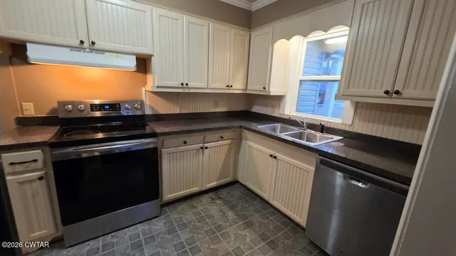 a kitchen with stainless steel appliances a stove sink and cabinets