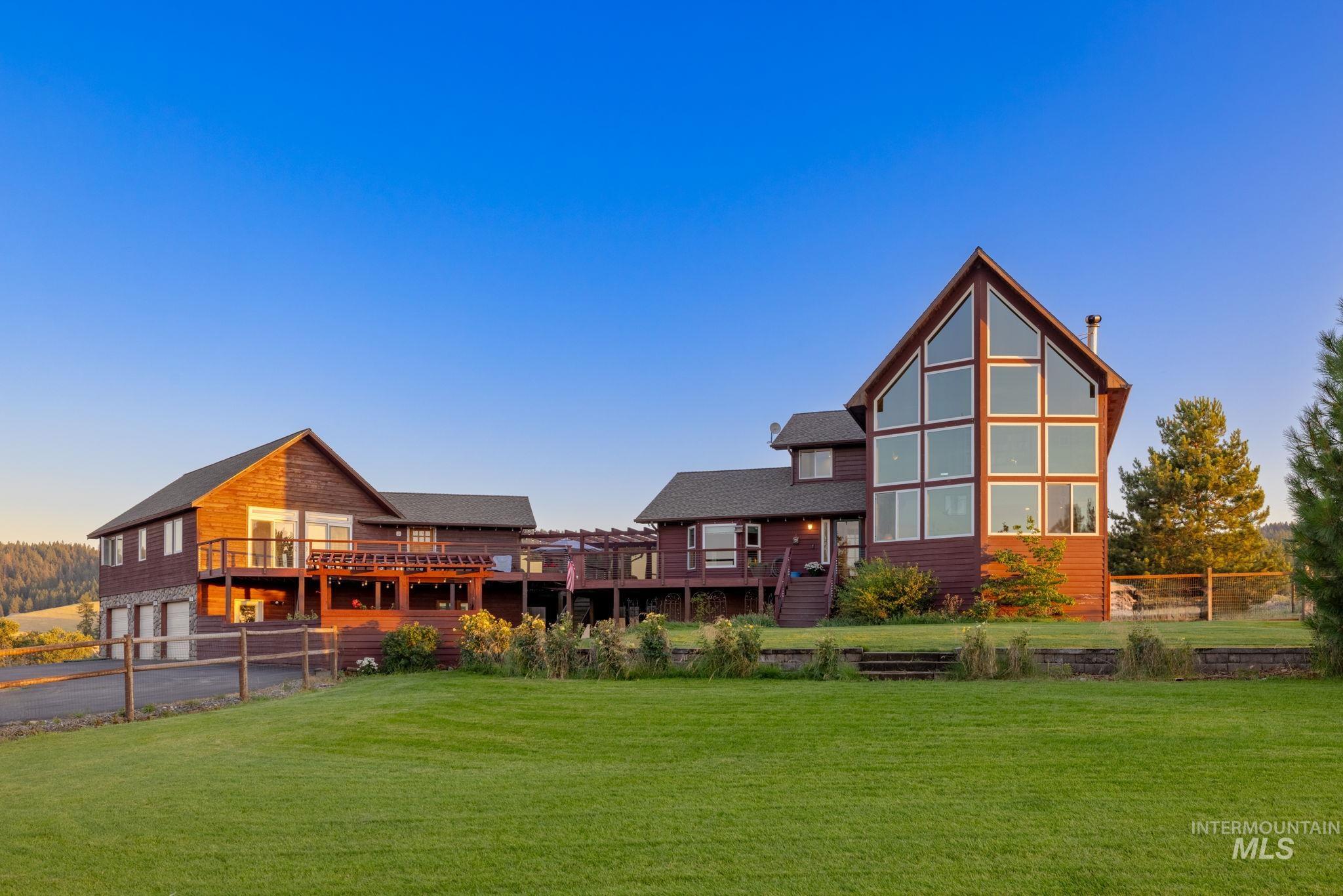 Back of property at dusk featuring a wooden deck and a garage