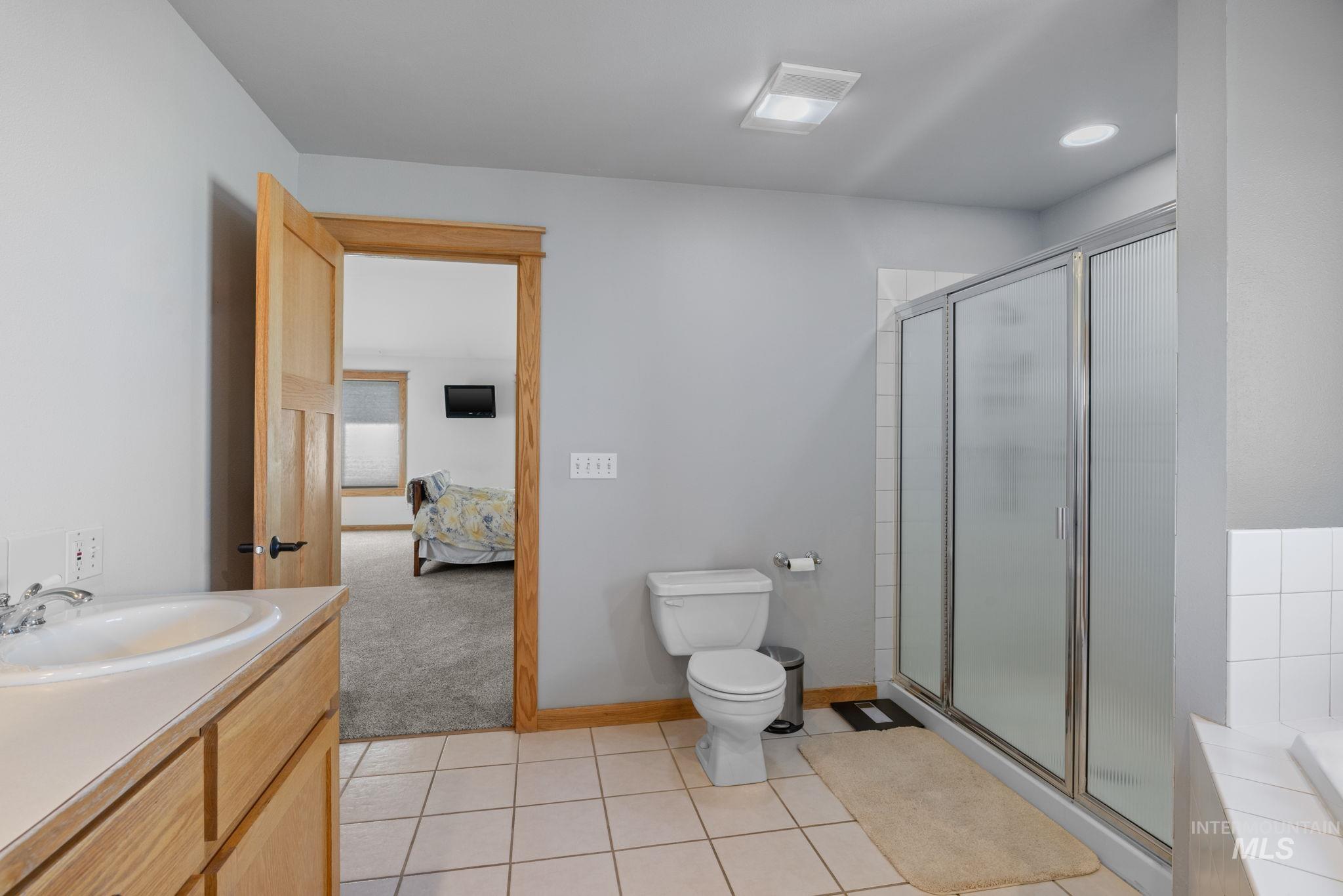 1199 Walker Road Viola, ID 83872 - Photo 19 of 50 Bathroom with a stall shower, vanity, connected bathroom, and tile patterned flooring