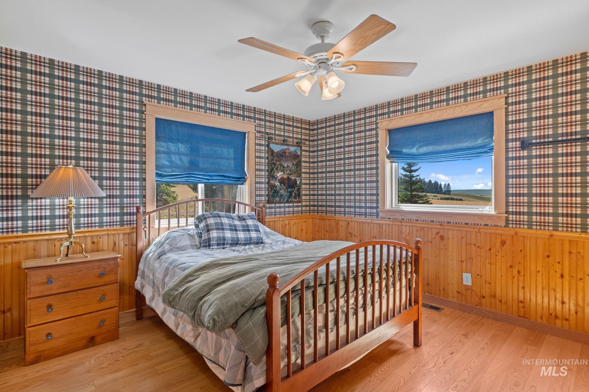 1199 Walker Road Viola, ID 83872 - Photo 20 of 50 Bedroom with wainscoting, wood walls, and wood finished floors