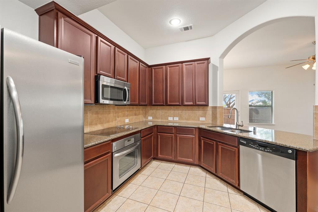 1013 Lucy Lane Allen, TX 75013 - Photo 14 of 30 a kitchen with stainless steel appliances granite countertop a sink stove and refrigerator