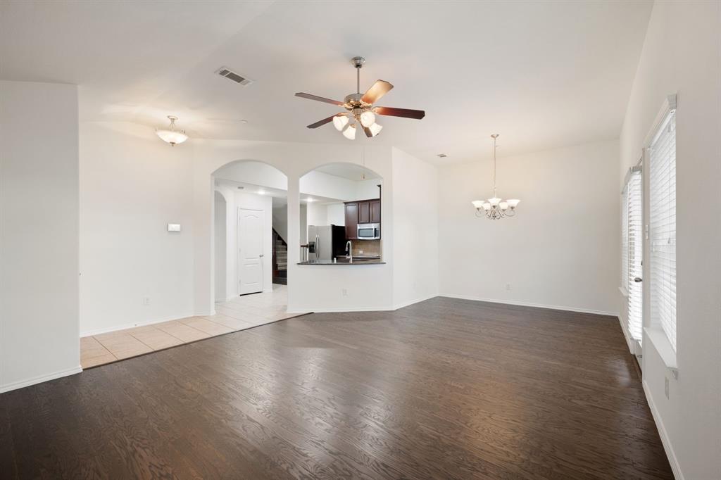 1013 Lucy Lane Allen, TX 75013 - Photo 5 of 30 an empty room with wooden floor ceiling fan and windows
