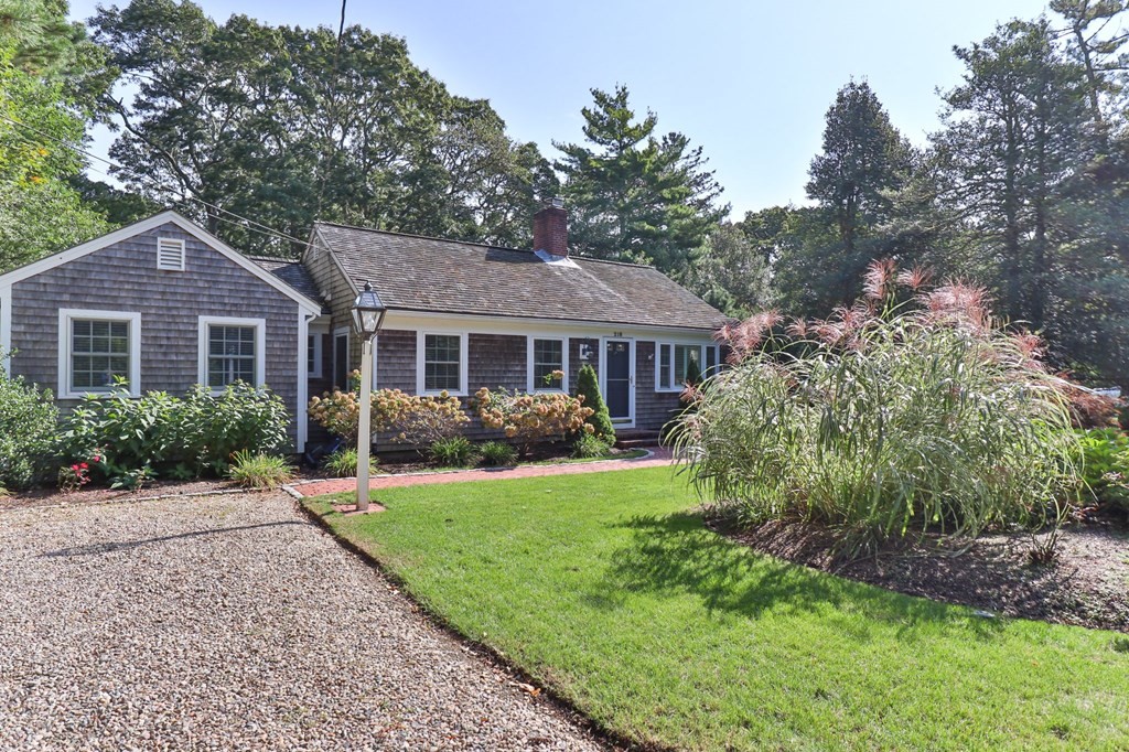 218 Scudder Road Barnstable, MA 02655 - Photo 1 of 36 a front view of a house with a yard and trees