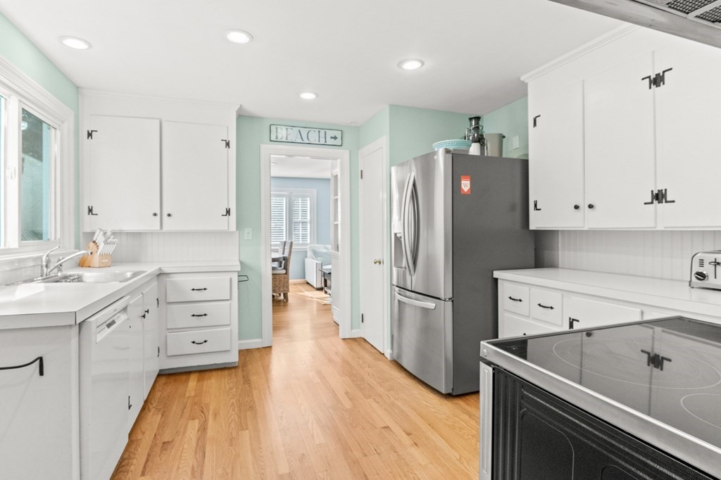 218 Scudder Road Barnstable, MA 02655 - Photo 8 of 36 a kitchen with a refrigerator sink and white cabinets