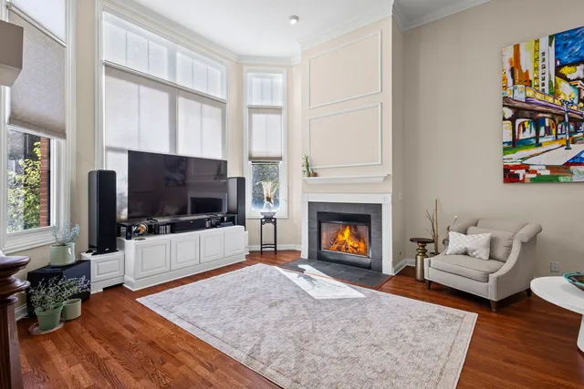 a living room with couches and a dining table with wooden floor