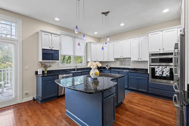 a kitchen with stainless steel appliances granite countertop a kitchen island a stove and a refrigerator
