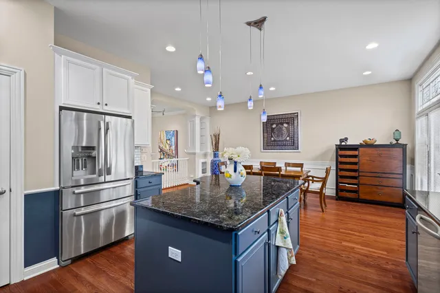 a bedroom with a large bed a lamp and wooden floor