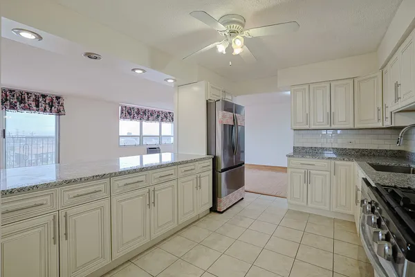 a kitchen with white cabinets and sink