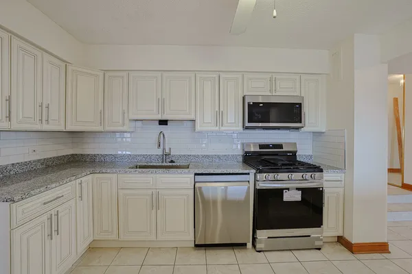 a kitchen with cabinets stainless steel appliances and a sink