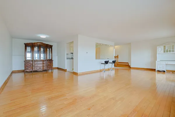 a view of empty room with wooden floor and floor to ceiling window and fireplace