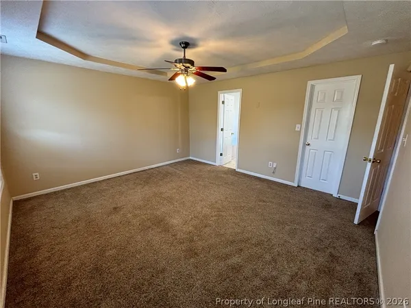 a view of an empty room with a chandelier fan