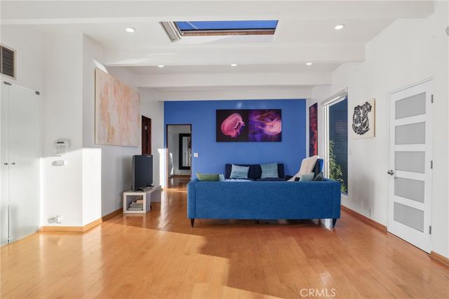 a bedroom with a large bed and a painting on the wall