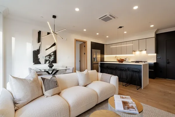 a living room with stainless steel appliances kitchen island granite countertop furniture and a view of kitchen