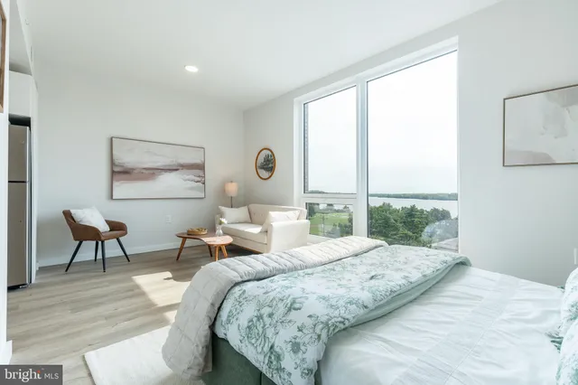 a bedroom with a bed and a large window