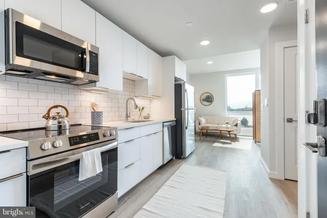 a kitchen with stainless steel appliances granite countertop a sink and stove top oven with wooden floor