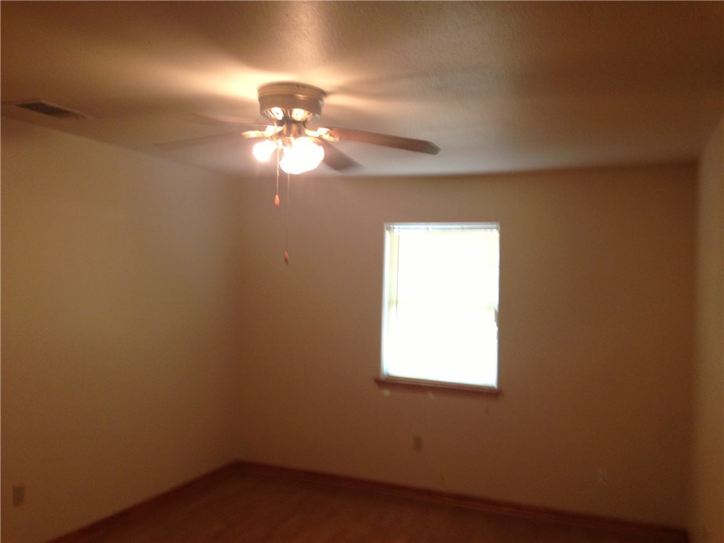 1704 Tillery Street Austin, TX 78721 - Photo 6 of 7 Ceiling fan with integrated lighting, wood-finish flooring, and a single window