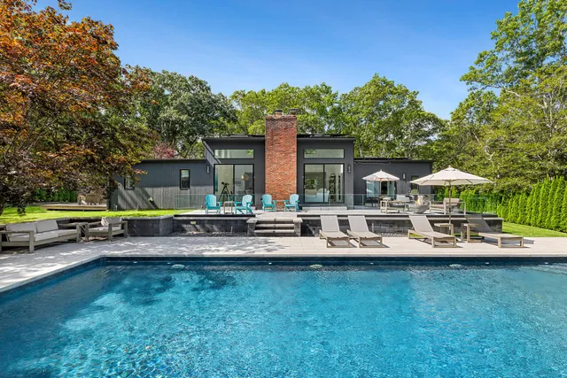 a view of a house with swimming pool and sitting area