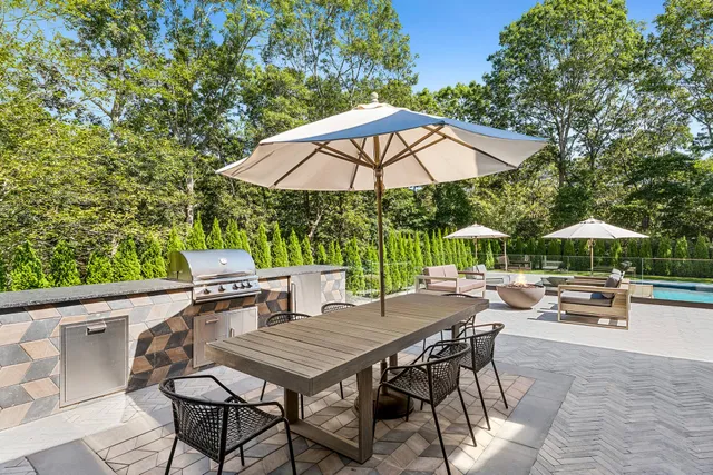 a view of backyard with seating space and wooden fence
