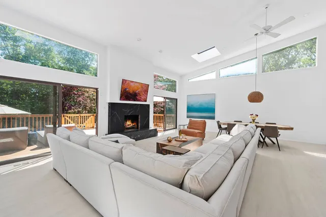 a living room with furniture a fireplace and a large window