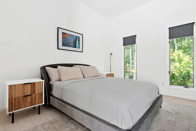 a large bed sitting in a bedroom next to a window