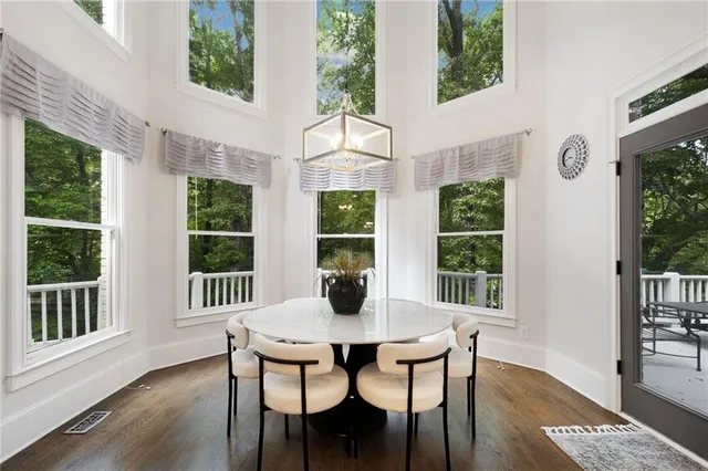 a dining room with furniture window and wooden floor