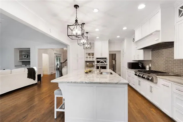 a large kitchen with kitchen island a stove a table and chairs in it