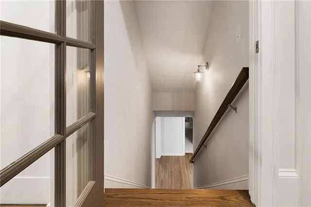 a view of staircase with wooden floor and railing