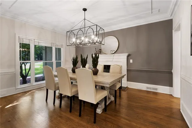 a view of a dining room with furniture a chandelier and wooden floor