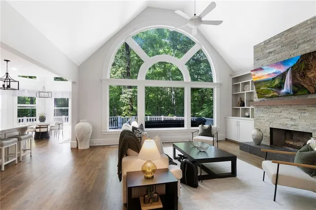 a living room with furniture fireplace and large windows