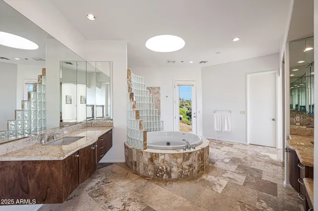 a bathroom with a granite countertop sink and a mirror