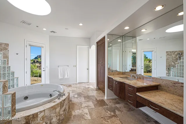 a bathroom with a tub a sink and glass door