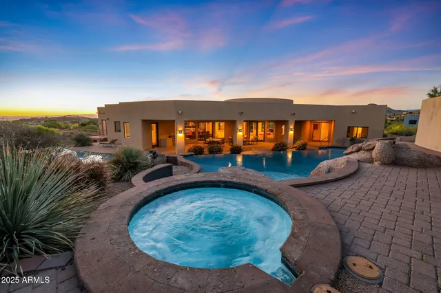 an aerial view of a house with a yard and a large tree
