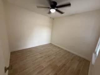 an empty room with a ceiling fan and carpet