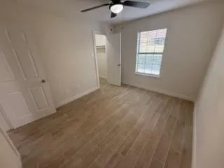 an empty room with windows and fan