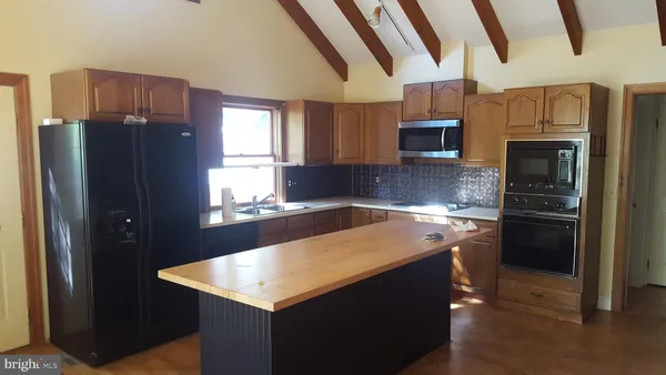 a kitchen with stainless steel appliances granite countertop a refrigerator and a stove top oven