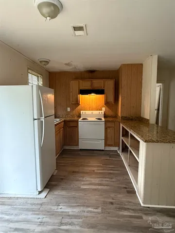 a kitchen with granite countertop a refrigerator and a sink