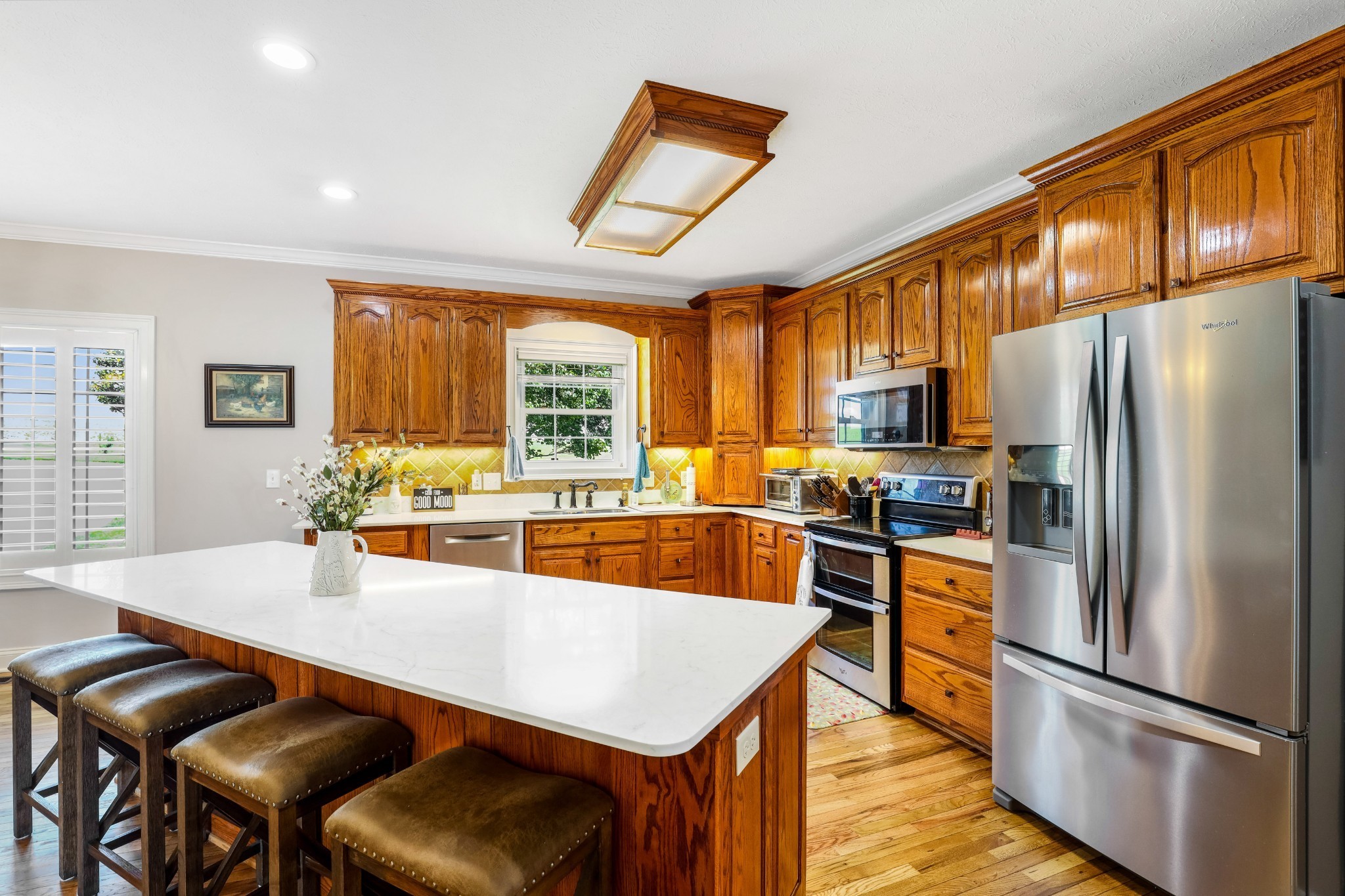 4984 Somerville Road Cross Plains, TN 37049 - Photo 38 of 57 a kitchen with stainless steel appliances granite countertop a refrigerator a stove a sink a dining table and chairs with wooden floor