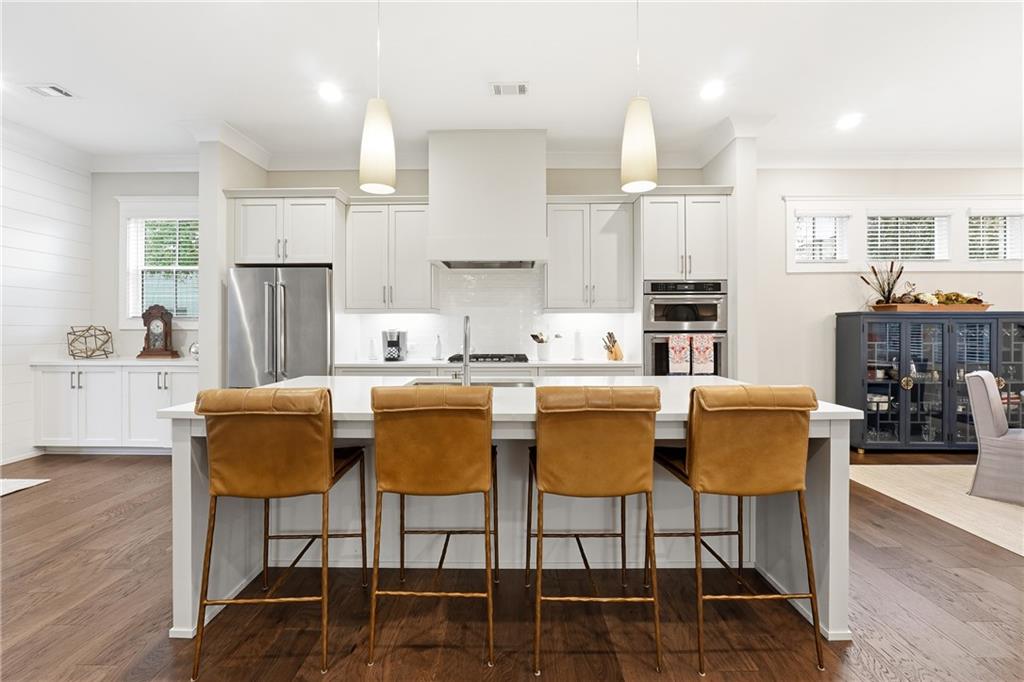 1307 Markham Road Atlanta, GA 30319 - Photo 11 of 47 a kitchen with stainless steel appliances kitchen island granite countertop a dining table chairs and a refrigerator