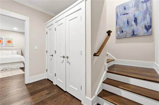 a view of a hallway with wooden floor and staircase