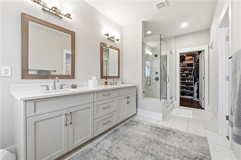 1307 Markham Road Atlanta, GA 30319 - Photo 27 of 47 a spacious bathroom with a shower sink double and mirror