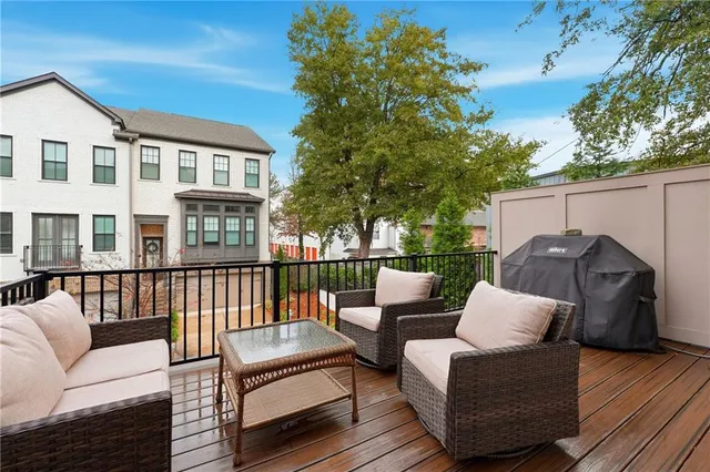 a balcony with couches and a potted plant on a table