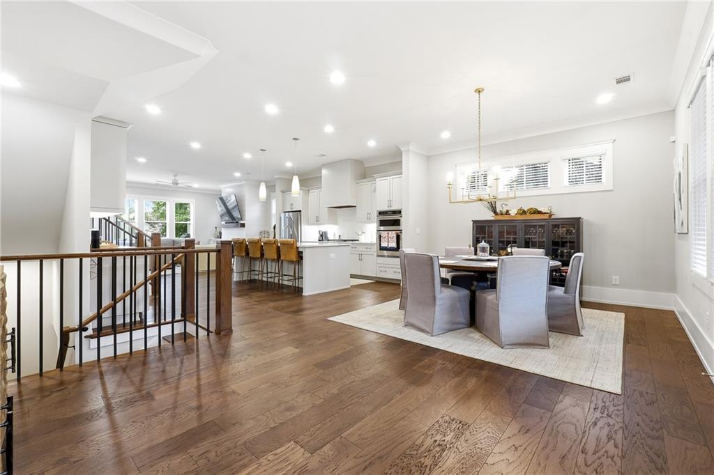 1307 Markham Road Atlanta, GA 30319 - Photo 6 of 47 a kitchen with stainless steel appliances kitchen island granite countertop a stove top oven a sink and a dining table with wooden floor