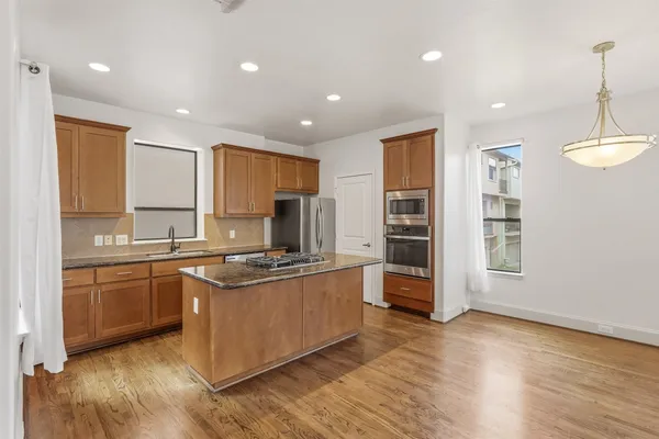 a kitchen with stainless steel appliances granite countertop a sink stove and refrigerator