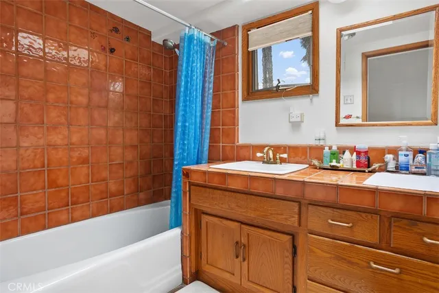 a bathroom with a granite countertop sink mirror bathtub and shower