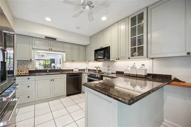 a kitchen with granite countertop a stove sink and cabinets