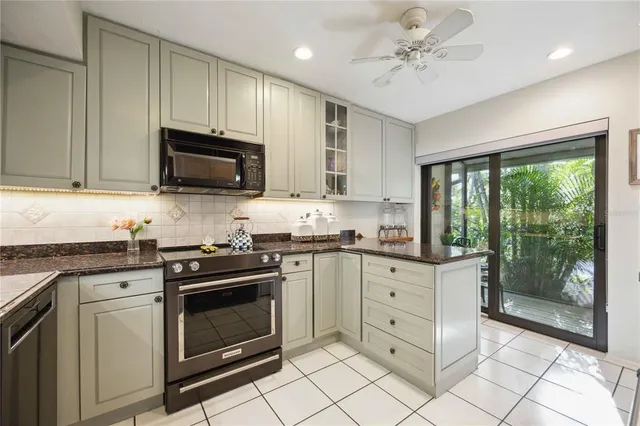 a kitchen with stainless steel appliances granite countertop a sink refrigerator and cabinets